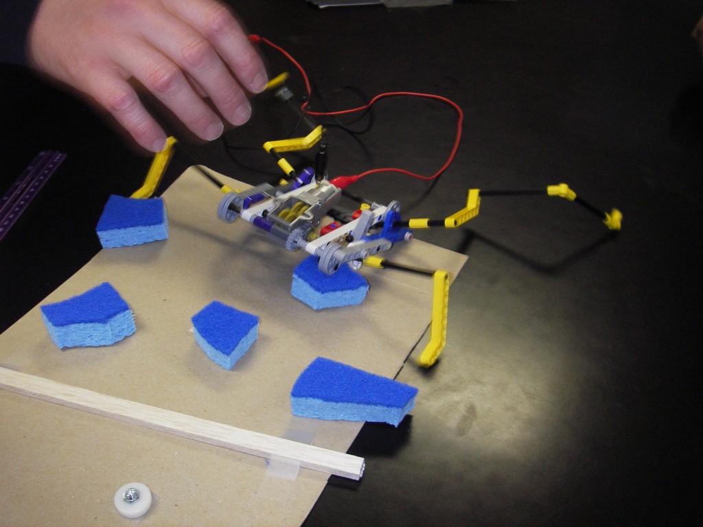 A small robot climbing over obstacles on a table
